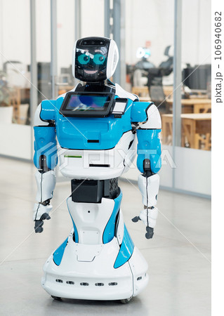 humanoid robot with a friendly face in the interior of a modern office 106940682