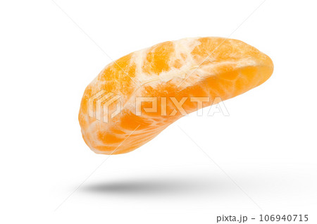 A slice of ripe and fresh tangerine on a white isolated background. Mandarin with shadow close-up hanging or falling. High quality photo. 106940715