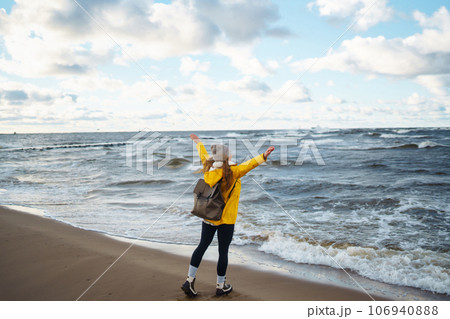 Happy tourist in a yellow jacket enjoying sea landscape at sunset. Travelling, lifestyle, adventure. Happy tourist in a yellow jacket enjoying sea landscape at sunset. Travelling, lifestyle, adventure. 106940888