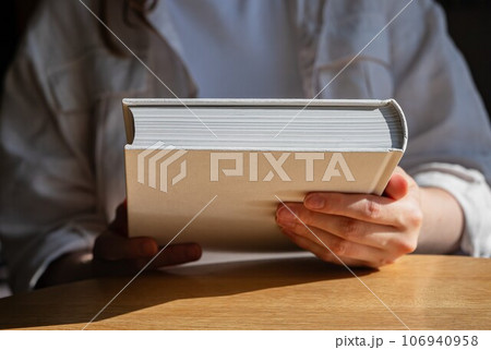 Hand holding new closed book for reading 106940958