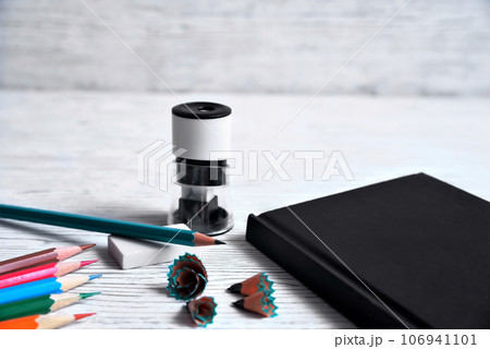 Pencils, notepad, sharpener, eraser and shavings from pencils on a gray non-uniform background 106941101