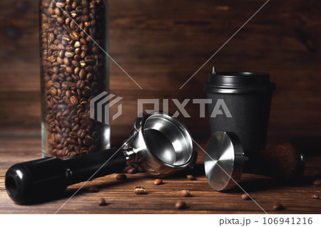 temper portafilter cardboard glass for coffee on a brown wooden background close-up copy space 106941216