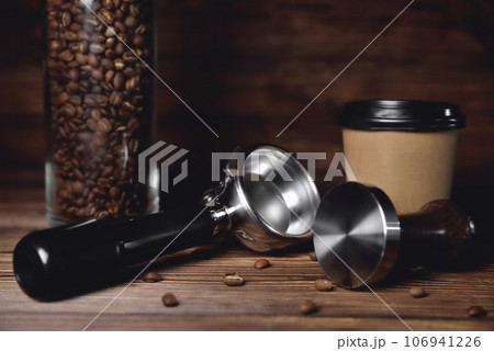 temper portafilter cardboard glass for coffee on a brown wooden background close-up copy space temper portafilter cardboard glass for coffee on a brown wooden background close-up copy space 106941226
