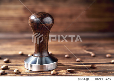 temper coffee beans on a brown wooden background blur 106941325