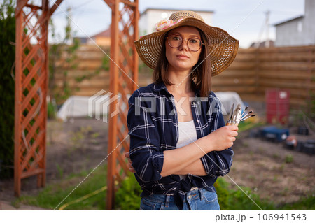 Portrait woman gardener in hat working in the garden in the backyard 106941543