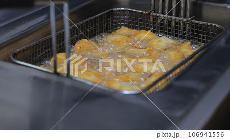 The process of cooking in the kitchen. Pasties with meat fried in sunflower oil, deep-fried. Fast food, junk food. Tatar, Caucasian, Greek cuisine. The process of cooking in the kitchen. Pasties with meat fried in sunflower oil, deep-fried. Fast food, junk food. Tatar, Caucasian, Greek cuisine. 106941556