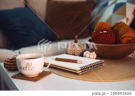 Start new autumn day with coffee cup with text hello and cozy fall decorations on table. Start of new day with hot beverage Start new autumn day with coffee cup with text hello and cozy fall decorations on table. Start of new day with hot beverage 106941680