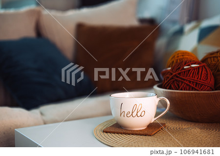 Start new autumn day with coffee cup with text hello and cozy fall decorations on table. Start of new day with hot beverage Start new autumn day with coffee cup with text hello and cozy fall decorations on table. Start of new day with hot beverage 106941681