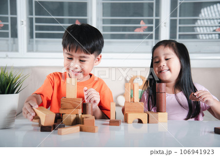 Children boy and girl playing with constructor wooden block building, Happy little kids play wood block stacking board game at home, activities learning creative, toys for preschool and kindergarten 106941923