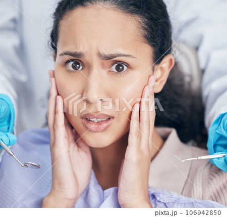 Trips to the dentists can be a nightmare. Shot of a young woman looking afraid at her dentists office. Trips to the dentists can be a nightmare. Shot of a young woman looking afraid at her dentists office. 106942850