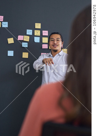 Meeting, brainstorming and presentation with team, man speaker and sticky note with leadership at startup. Collaboration, people in strategy planning workshop and ideas with presenter and audience Meeting, brainstorming and presentation with team, man speaker and sticky note with leadership at startup. Collaboration, people in strategy planning workshop and ideas with presenter and audience 106942978