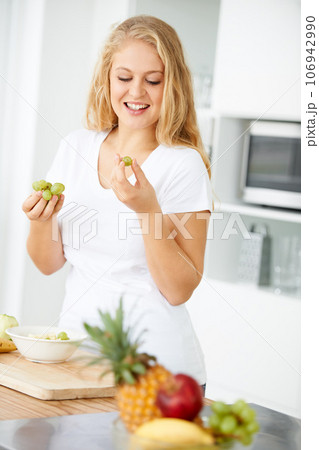 Fruits, eating grapes or happy woman with healthy morning meal or lunch meal or diet in kitchen at home. Breakfast, smile or vegan girl enjoying a fruit salad or food bowl to lose weight for wellness Fruits, eating grapes or happy woman with healthy morning meal or lunch meal or diet in kitchen at home. Breakfast, smile or vegan girl enjoying a fruit salad or food bowl to lose weight for wellness 106942990