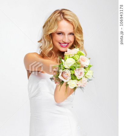 Its the perfect bouquet. Gorgeous young bride holding out her bouquet towards you - portrait. 106943178
