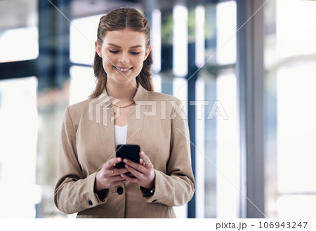 Sorting business matters straight from her phone. Shot of a young businesswoman using a cellphone in an office. 106943247