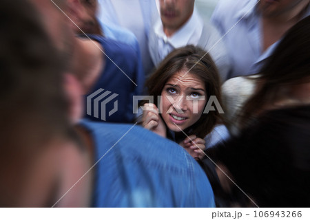 Drowning in people. Shot of a fearful young woman feeling trapped by the crowd. Drowning in people. Shot of a fearful young woman feeling trapped by the crowd. 106943266
