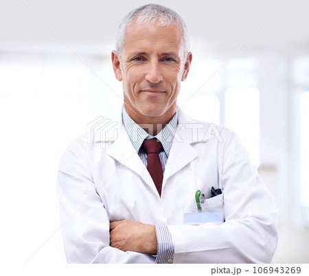 Healthcare, portrait of man doctor with arms crossed and in a hospital. Medical health wellness, specialist or stand and confident professional mature male surgeon or nurse at clinic for support 106943269