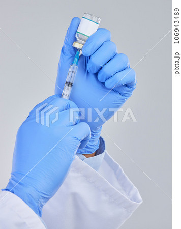 Vaccine vial, needle and doctor hands in studio for safety, healthcare and pharmaceutical medicine. Closeup person, vaccination and injection bottle for virus, immunity and medical antibiotics drugs 106943489