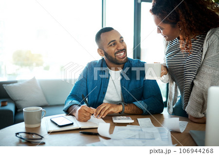 Couple talk about budget, finance and bills with paperwork of financial information, happy with savings and income. Mortgage, insurance and taxes, man and woman laugh together with home bookkeeping Couple talk about budget, finance and bills with paperwork of financial information, happy with savings and income. Mortgage, insurance and taxes, man and woman laugh together with home bookkeeping 106944268