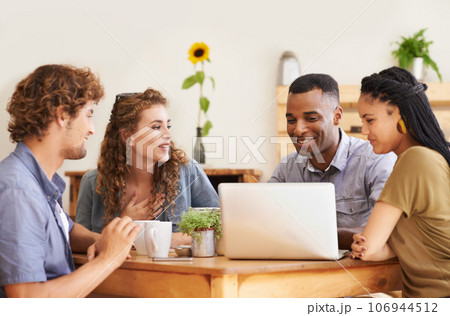 In good company. A group of friends sitting together in a coffee shop with a laptop. In good company. A group of friends sitting together in a coffee shop with a laptop. 106944512