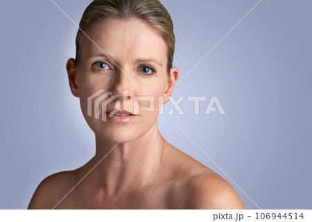 Face, beauty and portrait of mature woman doing cosmetic skincare facial isolated in a blue studio background. Cosmetics, care and old female model calm with natural skin due to anti aging Face, beauty and portrait of mature woman doing cosmetic skincare facial isolated in a blue studio background. Cosmetics, care and old female model calm with natural skin due to anti aging 106944514