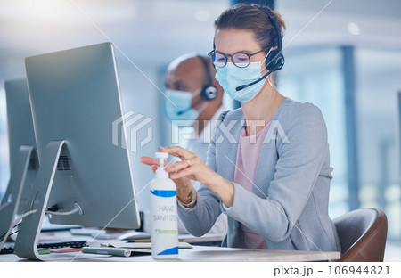 Sanitize, hygiene and compliance with covid19 regulations at call center with crm agent cleaning workstation. Woman working in customer service, making sure to leave desk fresh for the next operator 106944821