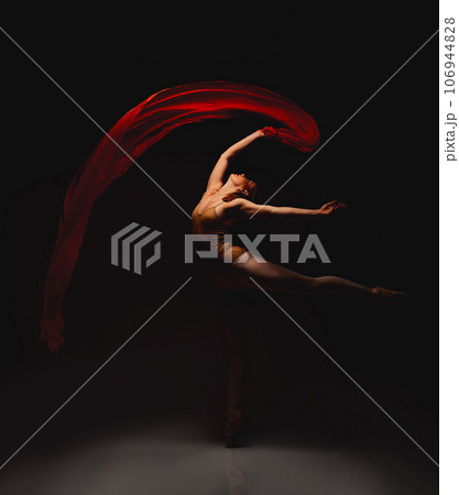 She lives for the arts. Shot of a performer dancing against a dark background. She lives for the arts. Shot of a performer dancing against a dark background. 106944828