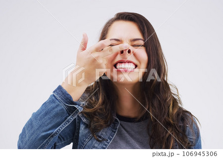 Smile, funny face and nose with a crazy woman in studio on a white background for carefree humor. Comic, comedy and showing nostrils with a weird young female person feeling playful while joking Smile, funny face and nose with a crazy woman in studio on a white background for carefree humor. Comic, comedy and showing nostrils with a weird young female person feeling playful while joking 106945306