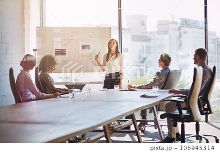 Woman speaker, meeting and business people with board, innovation or planning for marketing strategy. Leader, presentation or workshop for goal, teamwork or analysis of data with diversity in team 106945314