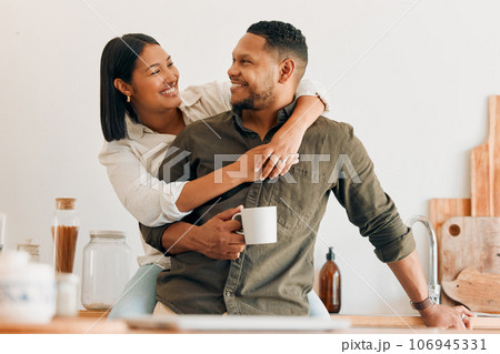 Happy, coffee and loving couple bonding and having fun while spending time together at home. Smiling, in love and carefree couple hugging and sharing a romantic moment while enjoying the weekend 106945331