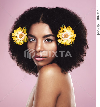 Portrait, woman and flowers in hair in studio, pink background and eco friendly makeup, beauty or natural skincare. Face of serious african model, floral cosmetics or afro for sustainable dermatology 106945538