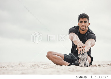 Make time for the things that give you more time. a young man stretching on the beach. Make time for the things that give you more time. a young man stretching on the beach. 106945857