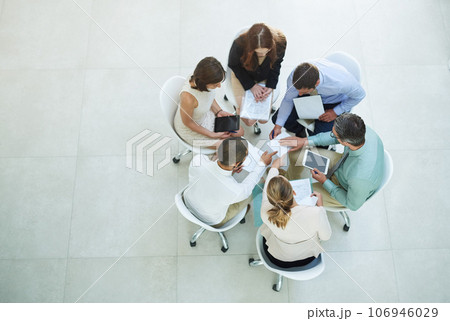 Brainstorming solutions. High angle shot of a group of businesspeople meeting in the office. 106946029