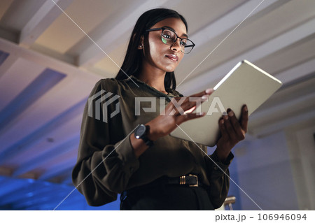 Work, night or woman reading on tablet for research, project or planning a proposal in office building, startup or professional employee. Overtime, working or search on internet, online communication 106946094