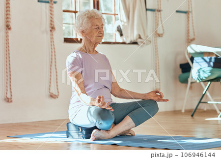 Elderly woman, yoga meditation and wellness while sitting on floor in home, gym or fitness club. Senior lady, retirement and zen exercise for health, mindfulness and peace in house, room or studio 106946144