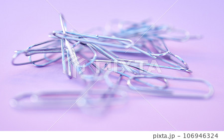 Paper clips together in pile, connected and a chain on purple background. Office supplies, organization and project management with paperclip for business strategy and planning to organize paperwork. Paper clips together in pile, connected and a chain on purple background. Office supplies, organization and project management with paperclip for business strategy and planning to organize paperwork. 106946324
