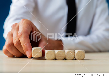Businessman placing five blank wooden dices in a row 106947019