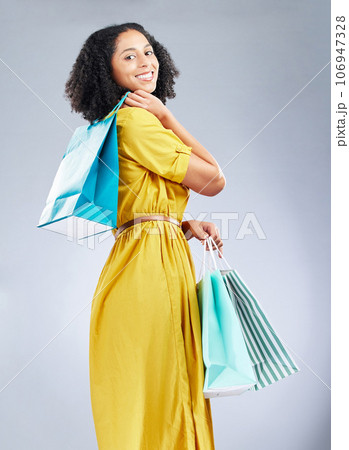 Shopping bag, fashion and young woman for happy discount, sale and retail promotion on a white background. Winning gift, giveaway and customer, model or african person in clothes portrait and studio 106947328