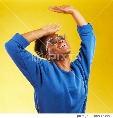 Fashion, freedom and fun with a black woman on a yellow background in studio for trendy gen z style. Relax, smile and excited with a happy young girl indoor to dance with a carefree expression Fashion, freedom and fun with a black woman on a yellow background in studio for trendy gen z style. Relax, smile and excited with a happy young girl indoor to dance with a carefree expression 106947399