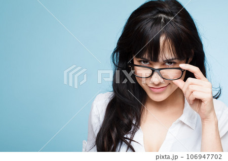 How may I be of service. Shot of a beautiful young woman posing against a studio background. 106947702