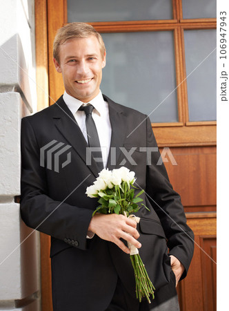 Love, portrait and man with flowers for valentines day, romance or gesture while standing against a wall background. Roses, happy and gentleman with bouquet for sweet, anniversary gift or first date 106947943