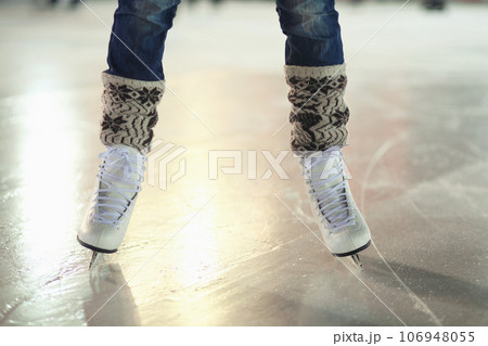 Ice skates, woman shoes and legs of skater training, recreation and skate on frozen floor, arena or stadium. Winter, entertainment and feet of female person balance, active or learning figure skating Ice skates, woman shoes and legs of skater training, recreation and skate on frozen floor, arena or stadium. Winter, entertainment and feet of female person balance, active or learning figure skating 106948055