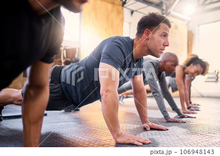 Wellness, team and push ups in gym, workout and fitness for focus, training together and health. Group, diversity or athletic people in sportswear being healthy, strong or with endurance for exercise Wellness, team and push ups in gym, workout and fitness for focus, training together and health. Group, diversity or athletic people in sportswear being healthy, strong or with endurance for exercise 106948143