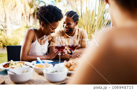 Conversation, friends at dinner in garden at party and celebration with diversity, food and wine at outdoor lunch Eating, men and women at table, fun people talking with drinks in backyard together. 106948715