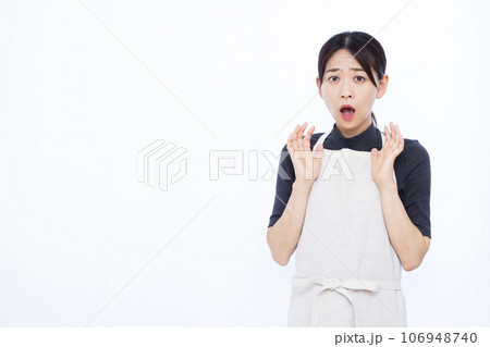 白い背景の前でビックリしている30代の主婦 白い背景の前でビックリしている30代の主婦 106948740