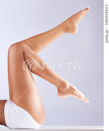 Skincare, body and woman legs with epilation, waxing and dermatology sitting in a studio. White background, laser and hair removal with self care, skin glow and wellness with feet pedicure and beauty Skincare, body and woman legs with epilation, waxing and dermatology sitting in a studio. White background, laser and hair removal with self care, skin glow and wellness with feet pedicure and beauty 106948823