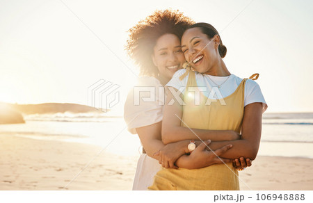 Portrait, hug and lgbt couple on the beach together for romance or relationship bonding on a date. Mockup, sunset and a gay woman with her lesbian girlfriend by the sea or ocean for their honeymoon 106948888