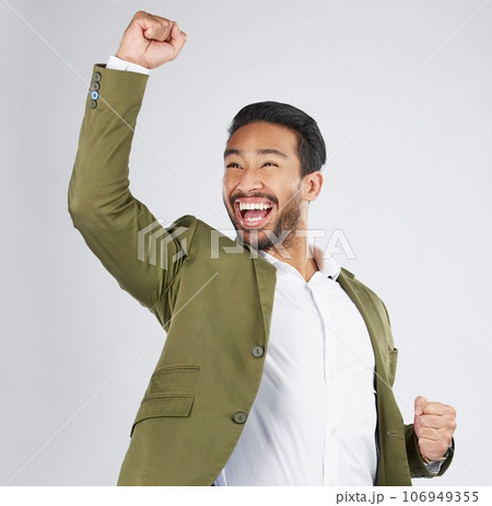 Happy asian man, fist pump and celebration in winning, success or promotion against a white studio background. Excited businessman smile in happiness for bonus, good news or victory with mockup space 106949355