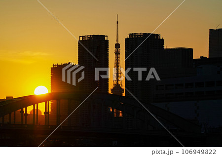 東京都/ 勝鬨橋とビルの隙間の東京タワー越しに見える夕陽（夕景） 106949822