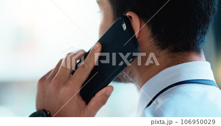 Business man talking on a phone call in an office. Closeup of corporate professional and entrepreneur from the back networking to build a successful empire. Communicating plans and deals with clients Business man talking on a phone call in an office. Closeup of corporate professional and entrepreneur from the back networking to build a successful empire. Communicating plans and deals with clients 106950029