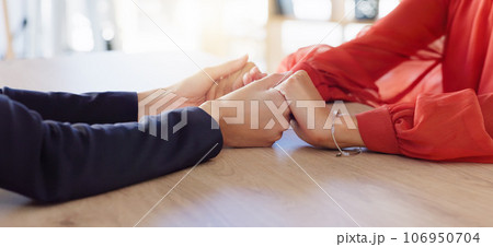 Love, empathy and friends holding hands in comfort, support or solidarity during grief, loss or mourning. Depression, mental health and anxiety with two people praying together in trust for help 106950704